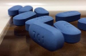 Blue PrEP pills on brown tabletop